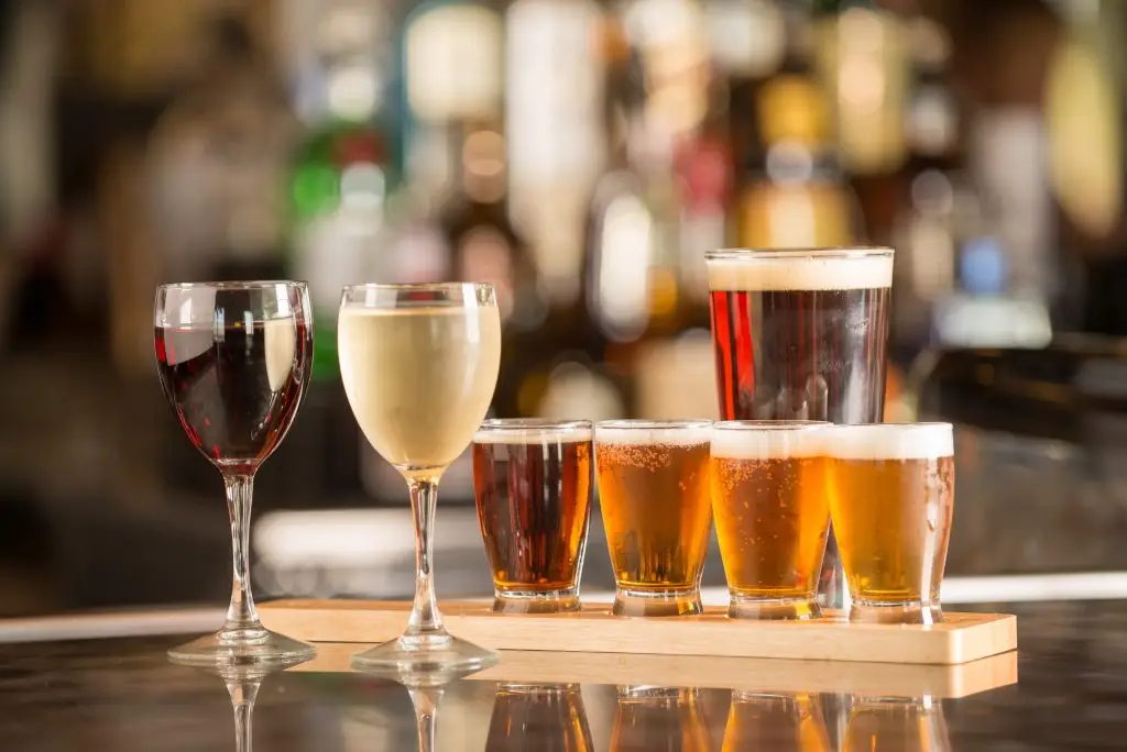 Filled beer and wine glasses displayed on a bar top.